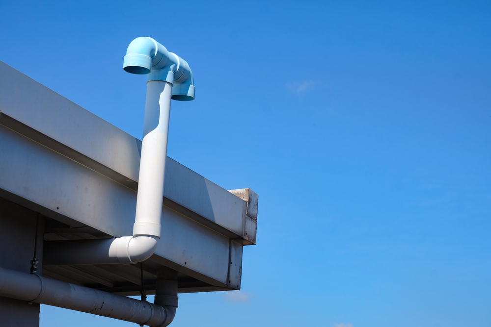 PVC pipe ventilation from the toilet in the building on blue sky background